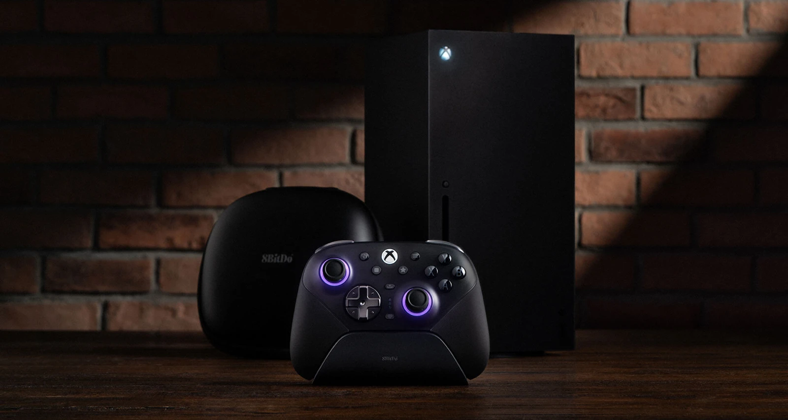 Чёрный геймпад 8BitDo Ultimate 3E на зарядной станции, рядом футляр и консоль Xbox Series X