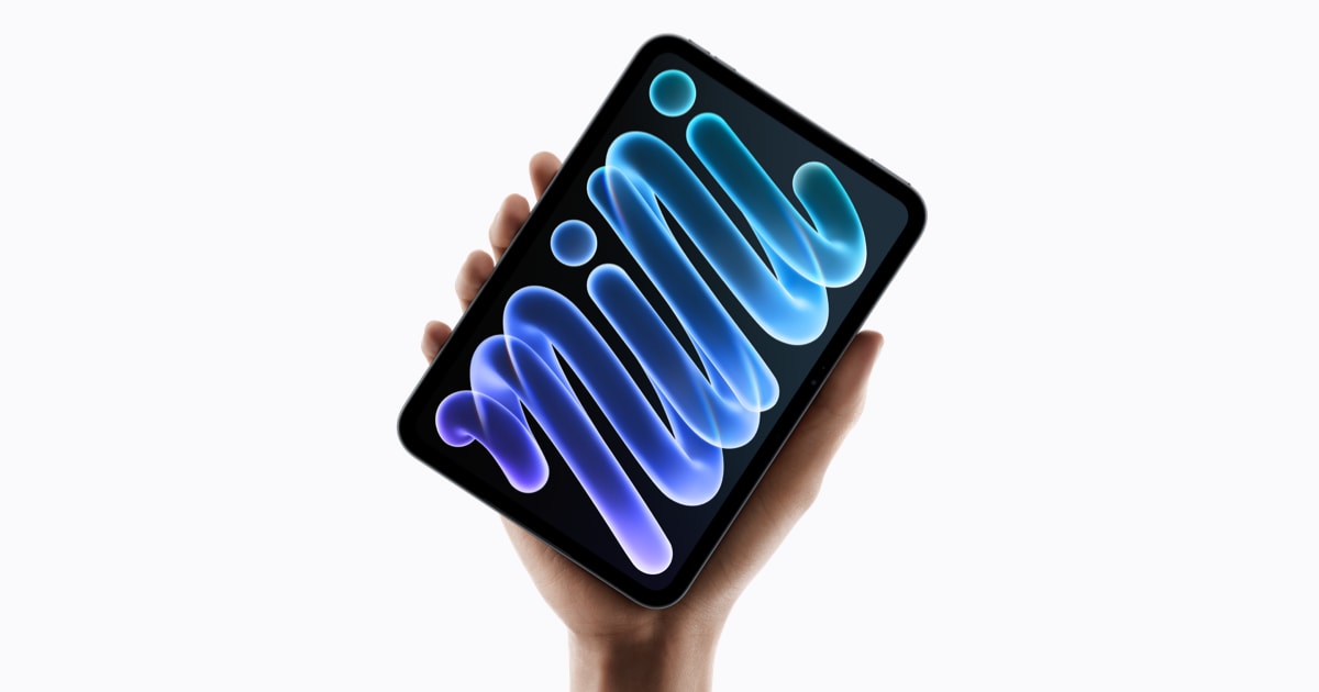 Новый iPad mini с сине-фиолетовыми обоями на экране в руке