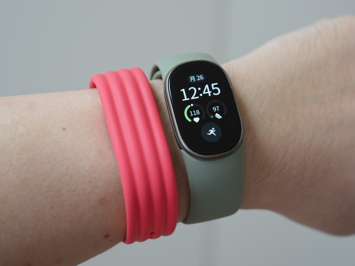 Fitbit Edge с зелёным ремешком и розовый Fitbit Air рядом на запястье