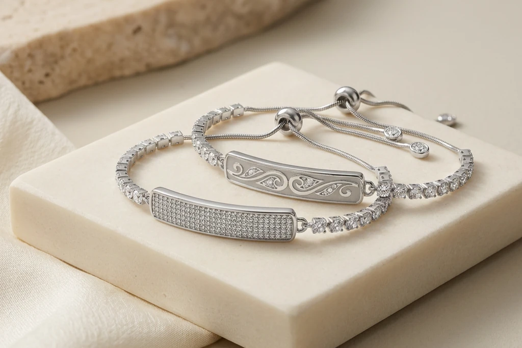 Два серебристых браслета Inllie Luna Glow и Luna Glow Luxe с декоративными камнями на светлой подставке