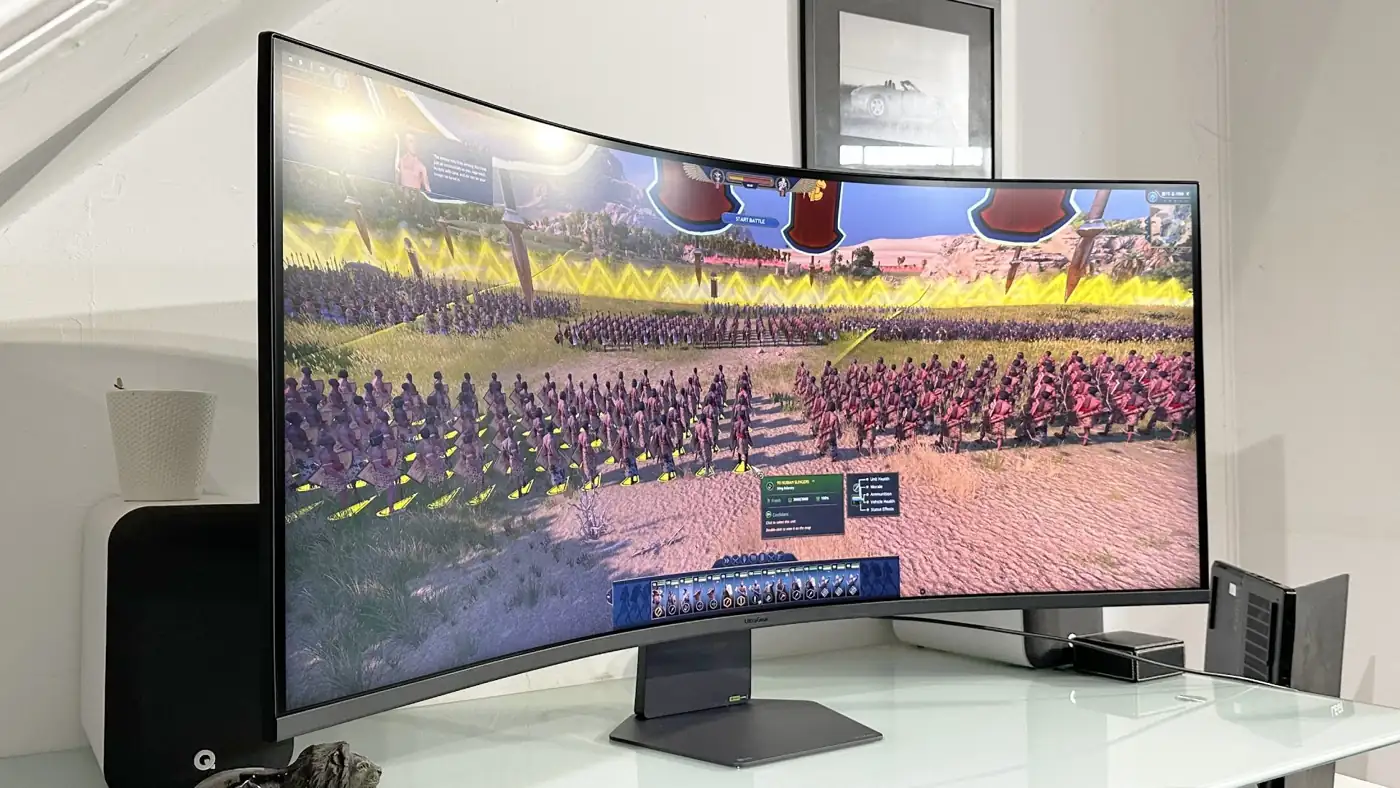 Изогнутый монитор LG UltraGear Evo 52G930B на столе со стратегической игрой на экране