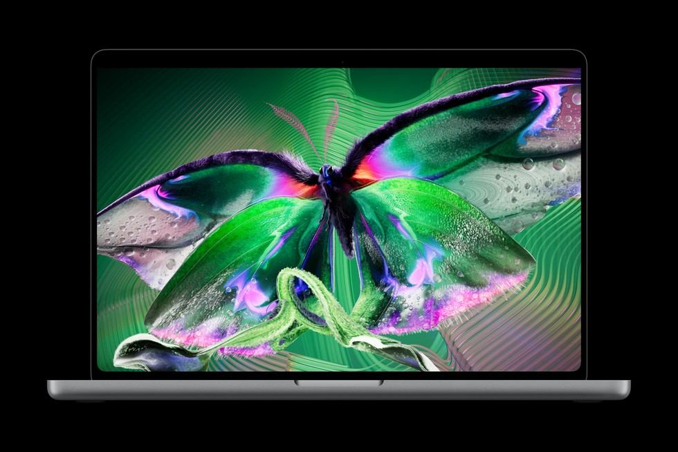 Открытый MacBook Pro на чёрном фоне с зелёной бабочкой на экране