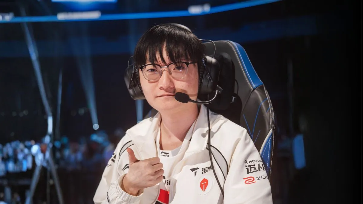 Tian из Top Esports в белой форме, очках и гарнитуре показывает большой палец на сцене Worlds 2026